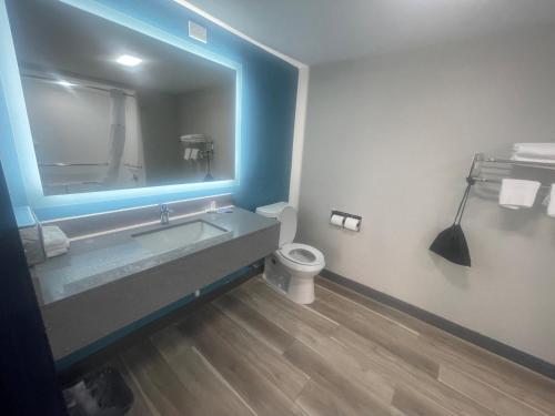 a bathroom with a sink and a toilet and a mirror at Days Inn by Wyndham Amarillo - Medical Center in Amarillo