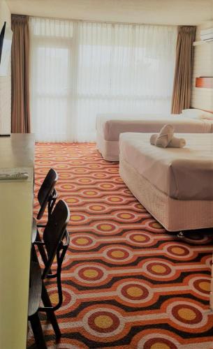a hotel room with two beds and a desk at Indian Ocean Hotel in Perth