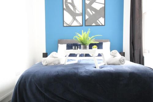 a blue bedroom with a bed with a white table at Amazing - 1BDR - Free Street Parking in Wolverhampton