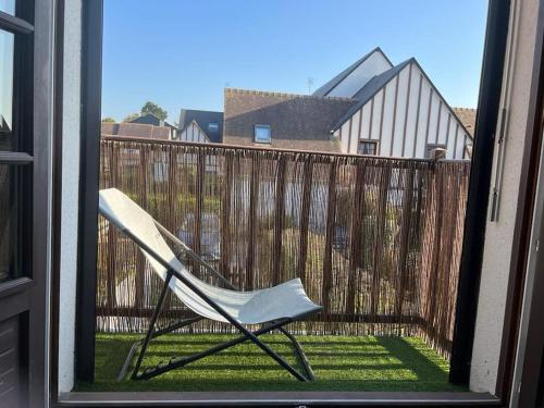 a chair sitting on a balcony with a fence at Charmant Duplex, 300 m de la mer in Courseulles-sur-Mer