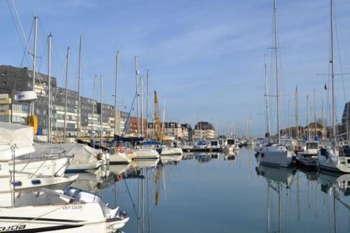 a bunch of boats are docked in a marina at Charmant Duplex, 300 m de la mer in Courseulles-sur-Mer