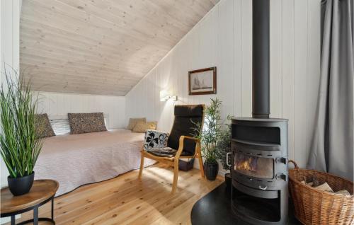 1 dormitorio con 1 cama y estufa de leña en Beautiful Home In Nex With Sauna, en Vester Sømarken