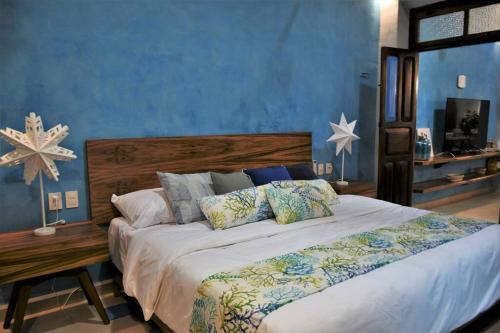 a bedroom with a large bed with a blue wall at Trilliza Azul in Campeche