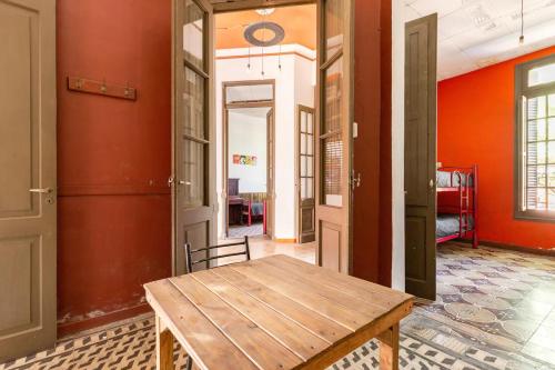 Habitación con mesa de madera y paredes de color naranja. en Como en casa, Mendoza en Godoy Cruz