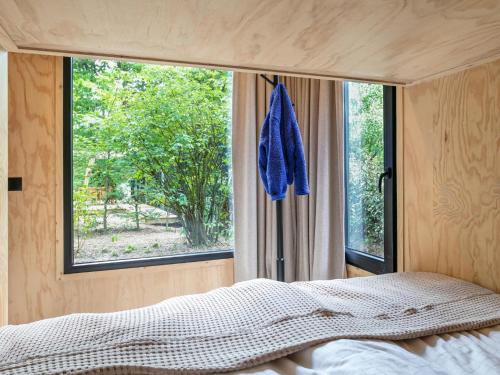 a bedroom with a bed and a large window at TED Tiny House in Nunspeet