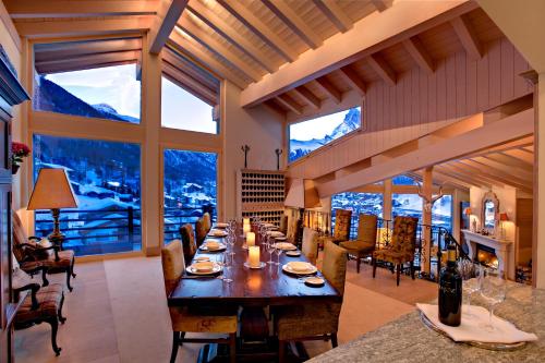 a large dining room with a long table and chairs at Chalet Grace in Zermatt