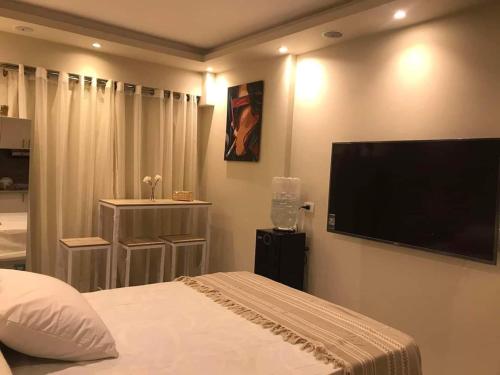 a bedroom with a large flat screen tv on the wall at غرفة فندقية في جولف بورتو مارينا in El Alamein