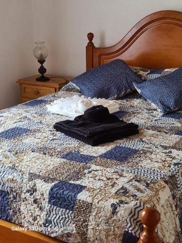 a bed with a blue and white quilt on it at AL Luso Brasileiro in Lajes das Flores