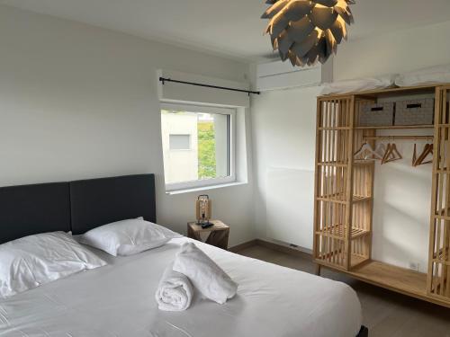 - une chambre avec un lit doté de draps blancs et une fenêtre dans l'établissement ENTRE NOUS CITY, à Annecy
