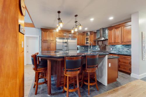 a kitchen with wooden cabinets and a large island with bar stools at Lobster Shack in Boothbay
