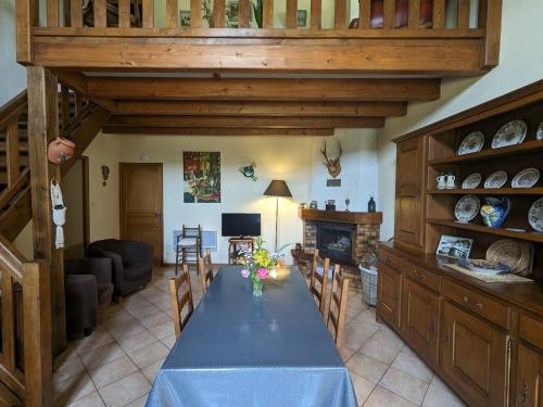 une salle à manger avec une table bleue et une cheminée dans l'établissement Maison de charme près de Neufchâteau avec jardin, terrasse et jeux extérieurs - FR-1-589-163, à Saint-Ouen-lès-Parey