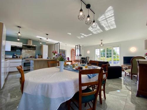 une cuisine et un salon avec une table et des chaises dans l'établissement Appartement Confort avec Suite Parentale et Équipements pour Bébé à Saint-Michel-Chef-Chef - FR-1-306-1232, à Saint-Michel-Chef-Chef