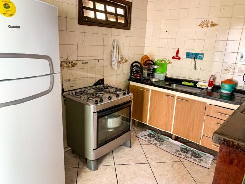 a kitchen with a stove and a refrigerator at Guest House do Magoo in Arraial do Cabo