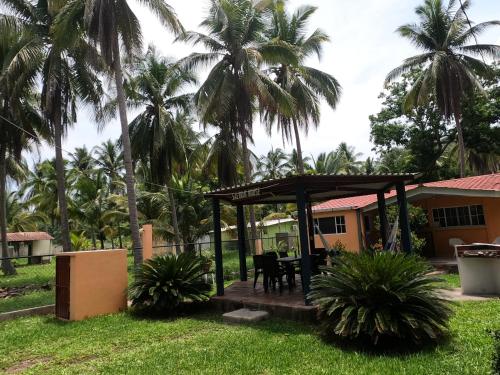 a gazebo in the yard of a house with palm trees at SALIMAR - Barra de Santiago in Barra de Santiago