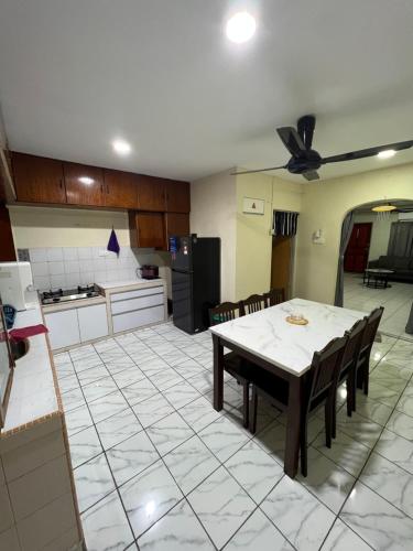 a kitchen and dining room with a table and chairs at JL Homestay Taman Pertama Satu in Lahad Datu