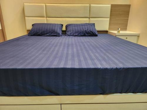 - un grand lit avec des draps violets dans une chambre dans l'établissement Gated Family House- next to MRSM, à Kampong Kawak