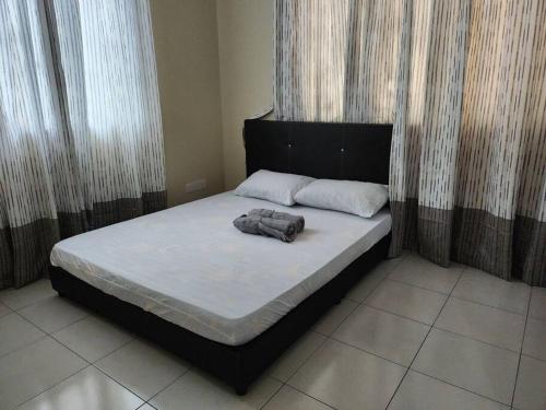 - un lit avec une tête de lit noire et 2 oreillers dans l'établissement Gated Family House- next to MRSM, à Kampong Kawak