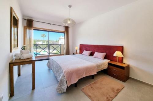 ein Schlafzimmer mit einem großen Bett und einem großen Fenster in der Unterkunft Cozy Corcovada T1 in Albufeira