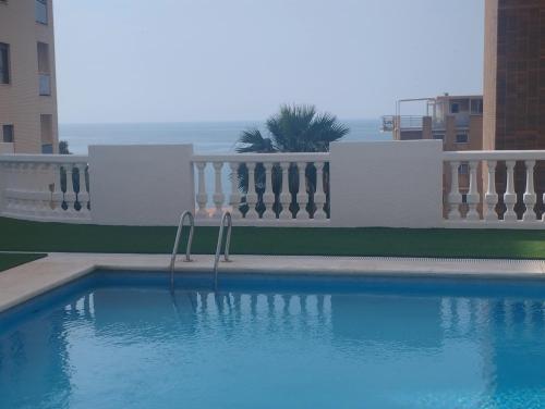 a swimming pool in front of a building at A 50 metros del mar y en 2 paradas de bus estas en el centro de Alicante in Alicante