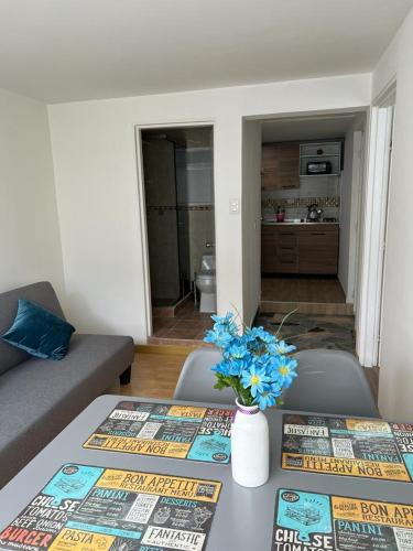 a living room with a table with blue flowers on it at Aparta-estudio Ciudad Jardin Norte 202 in Bogotá