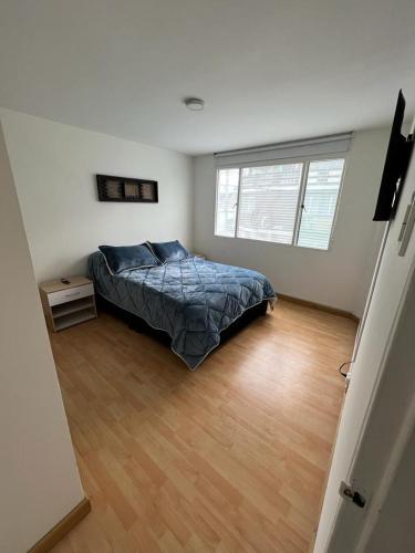 una camera con letto e pavimento in legno di Aparta-estudio Ciudad Jardin Norte 202 a Bogotá