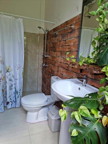 a bathroom with a white toilet and a sink at Rumah Tropis - Lantai 1, single room in Parit