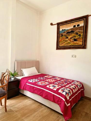 Parit的住宿－Rumah Tropis - Lantai 1, single room，卧室配有一张床,墙上挂有绘画作品