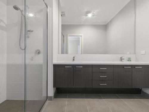 La salle de bains est pourvue d'une douche, d'un lavabo et d'un miroir. dans l'établissement Breeze on Inn Surfside, à Inverloch