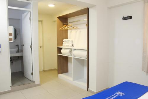 a bathroom with a closet with towels and a mirror at Hotel Luxotel Chincha in Chincha Alta
