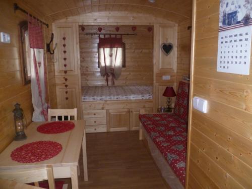 Habitación pequeña con mesa y banco en una cabaña en Comme Sur Des Roulottes, en Saint-Nectaire