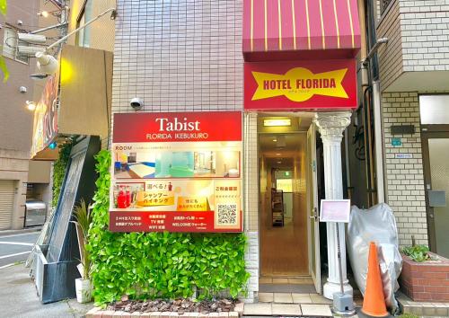 a building with signs on the side of it at Tabist Hotel Florida Ikebukuro in Tokyo