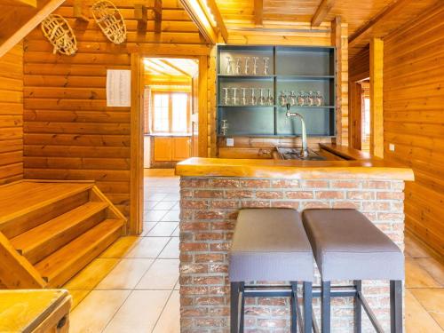a kitchen with a sink and a counter with stools at Chalet Comfort Near Durbuy in Barvaux