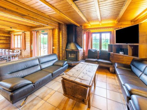 a living room with leather couches and a flat screen tv at Chalet Comfort Near Durbuy in Barvaux