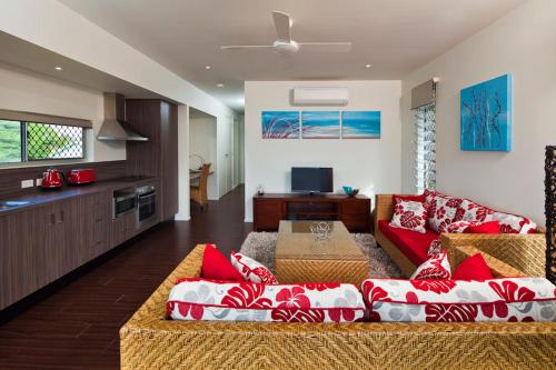 un soggiorno con divano rosso e una cucina di Island Villas a Thursday Island