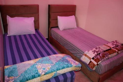 dwa łóżka siedzące obok siebie w pokoju w obiekcie la perle rare de Sidi Ifni w mieście Sidi Ifni