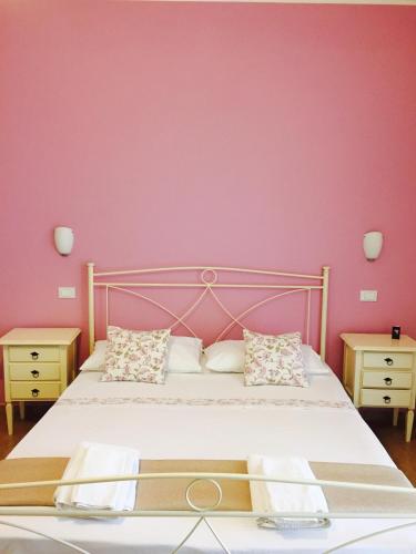 a bedroom with a bed with a pink wall at Zahir da Cleo in Castro di Lecce