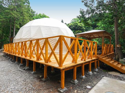 a building with a domed roof and a wooden frame at リバーサイドグランピングNuts in Higashiomi