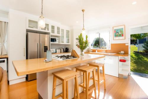 a kitchen with a large island with bar stools at Reflections Pet Friendly Waterfront in Basin View