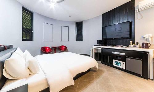 - une chambre avec un lit et une télévision à écran plat dans l'établissement Paju Picasso, à Paju