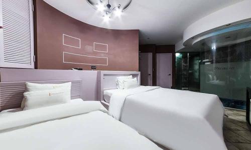 - 2 lits blancs dans une chambre avec un mur dans l'établissement Paju Picasso, à Paju