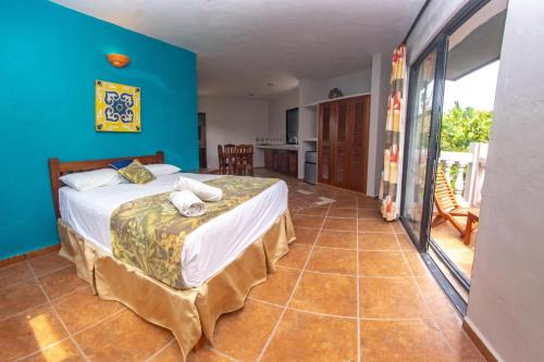 1 dormitorio con cama y pared azul en Margarita del Sol Hotel Costa Maya, en Mahahual