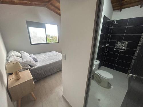 Dormitorio pequeño con cama y ducha en Medellin Hermoso apartamento, en Medellín