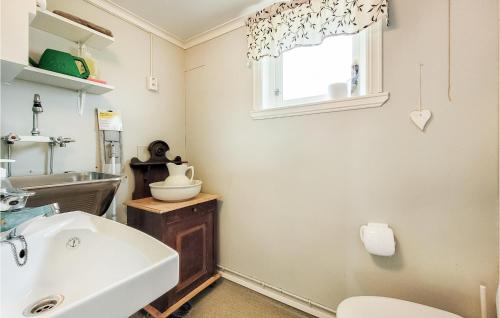 KvalvågにあるBeautiful Home In Sveio With Wifiのバスルーム(洗面台、トイレ付)、窓が備わります。