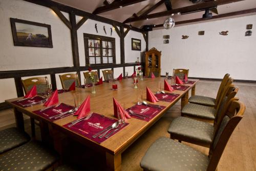 a long table in a room with red napkins on it at Hotel Niedźwiadek in Wdzydze Kiszewskie