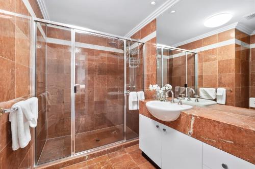 a bathroom with a sink and a shower at Luxury Oceanview Penthouse Cairns City in Cairns