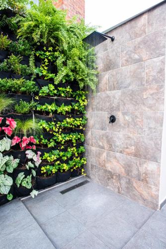 a stone wall with plants and flowers on it at Vita Hotel Boutique - Aire Acondicionado & Desayuno in Medellín