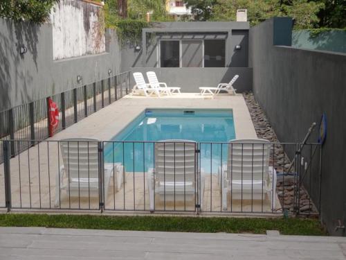 a swimming pool with chairs and a fence at Paseo Victorica - Vista al Río in Tigre