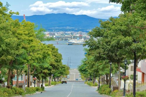 an empty street with trees and a view of the water at Tokyu Stay Hakodate Asaichi Akarinoyu in Hakodate