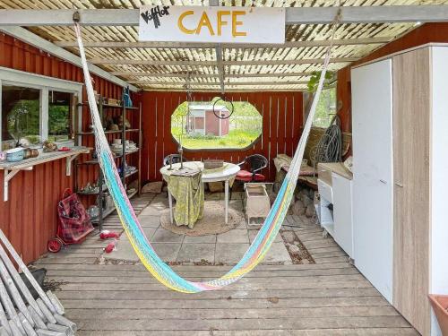 a porch with a hammock and a cafe sign on it at 4 person holiday home in FURUBY-By Traum in Fagereke