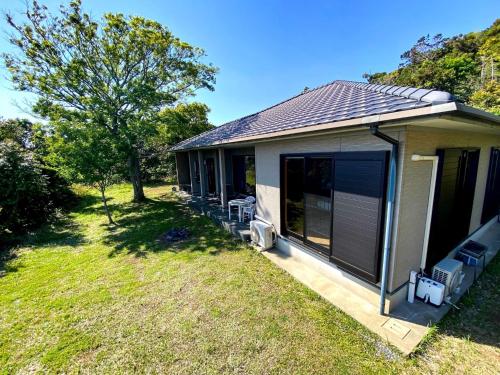 a house with a porch with chairs and a yard at Nonoya - Vacation STAY 78469v in Goto